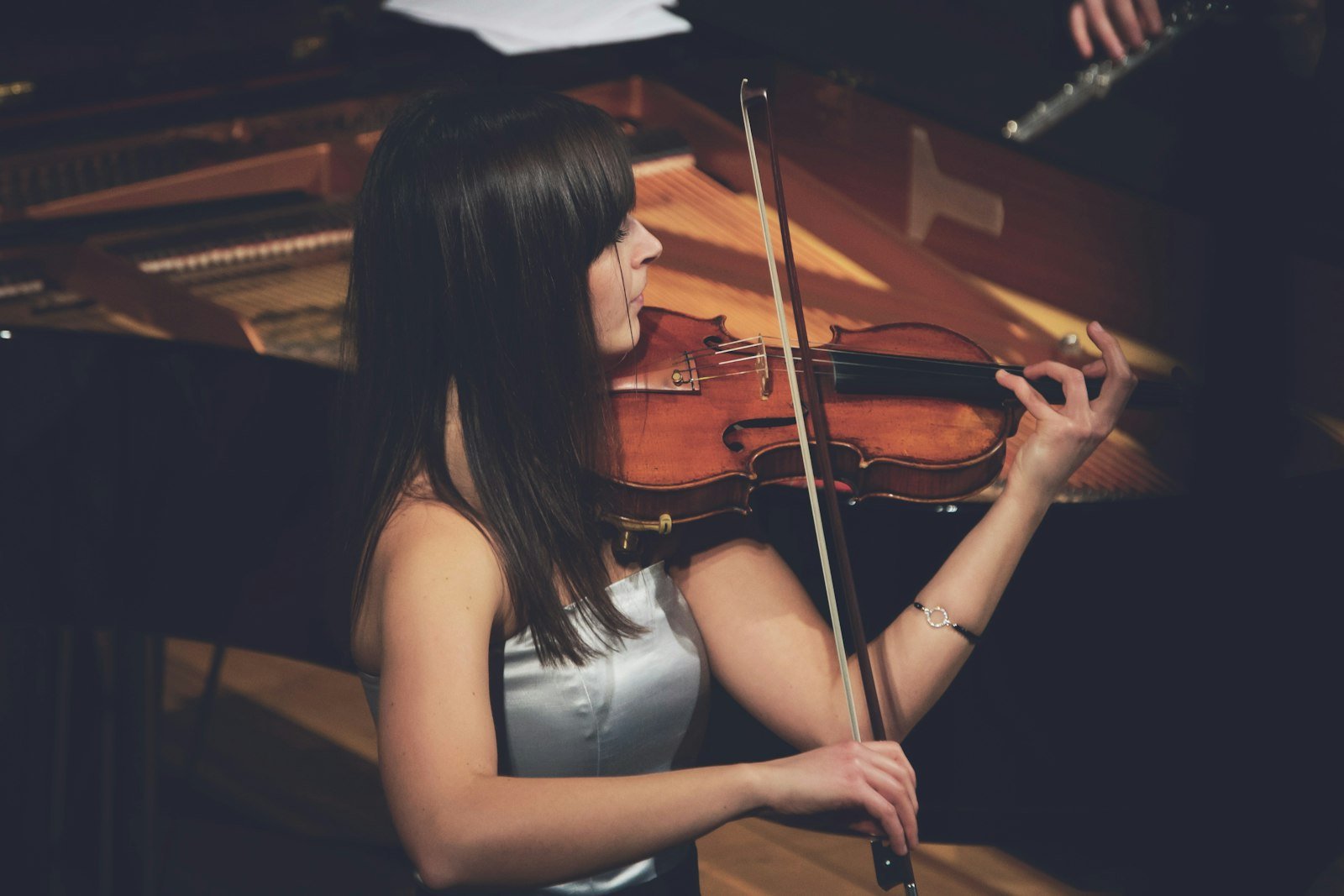 Violinista tocando junto a un piano de cola