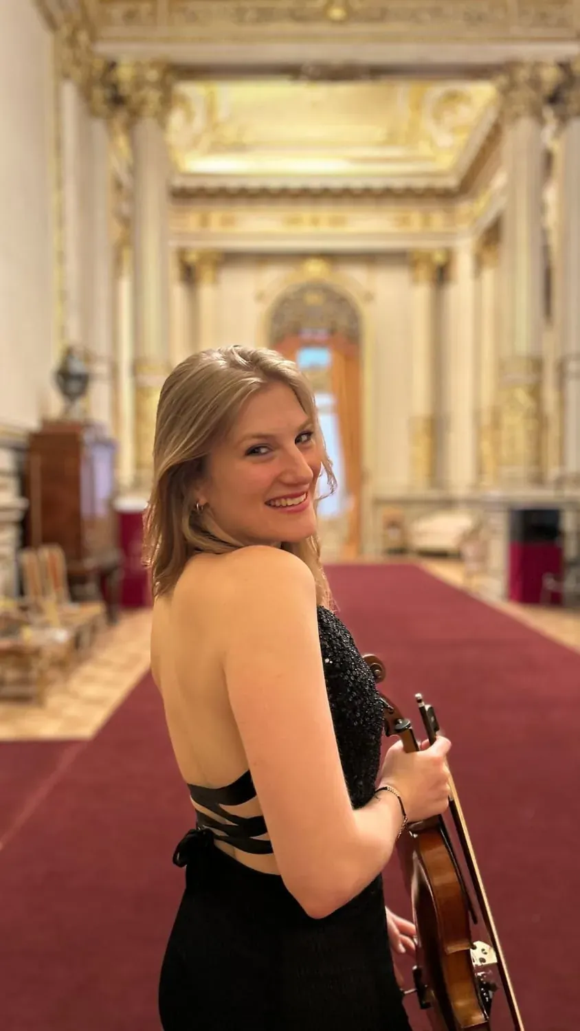 Tiziana Mingrone con violín en un pasillo dorado del Teatro Colón